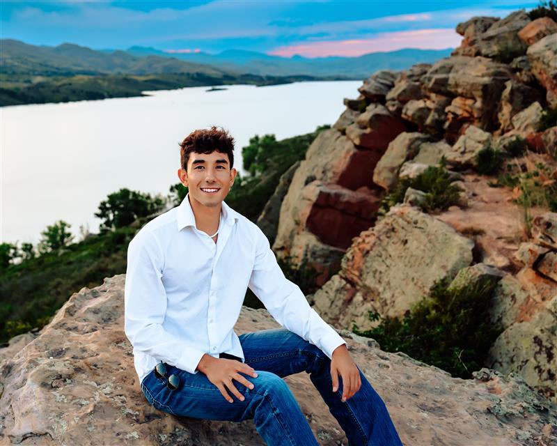 Gabe, aspiring professional aviator, photographed outdoors with a scenic mountain lake backdrop